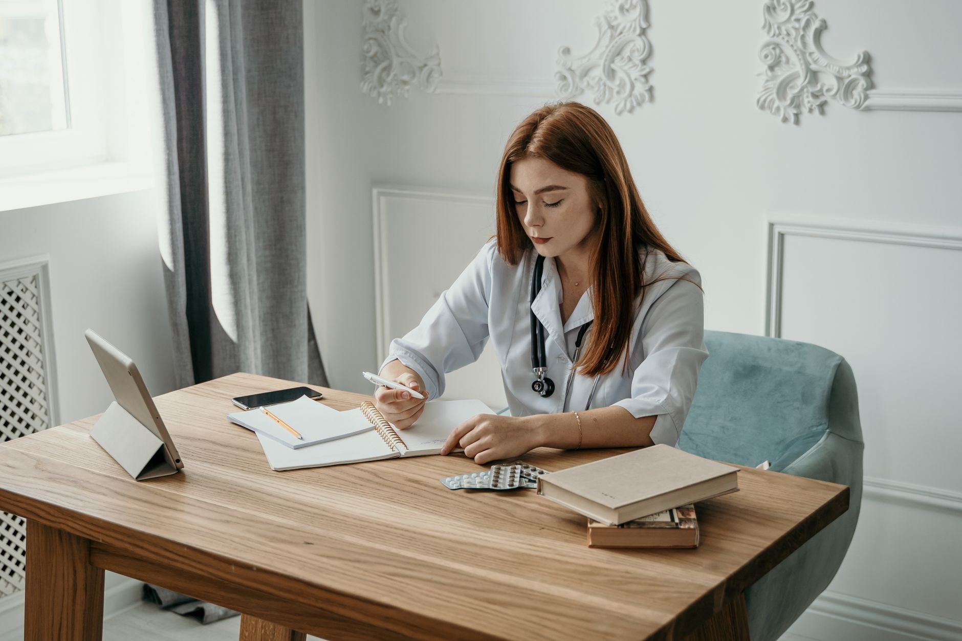 Notițe și un stetoscop așezate pe un birou, pregătire pentru o consultație medicală